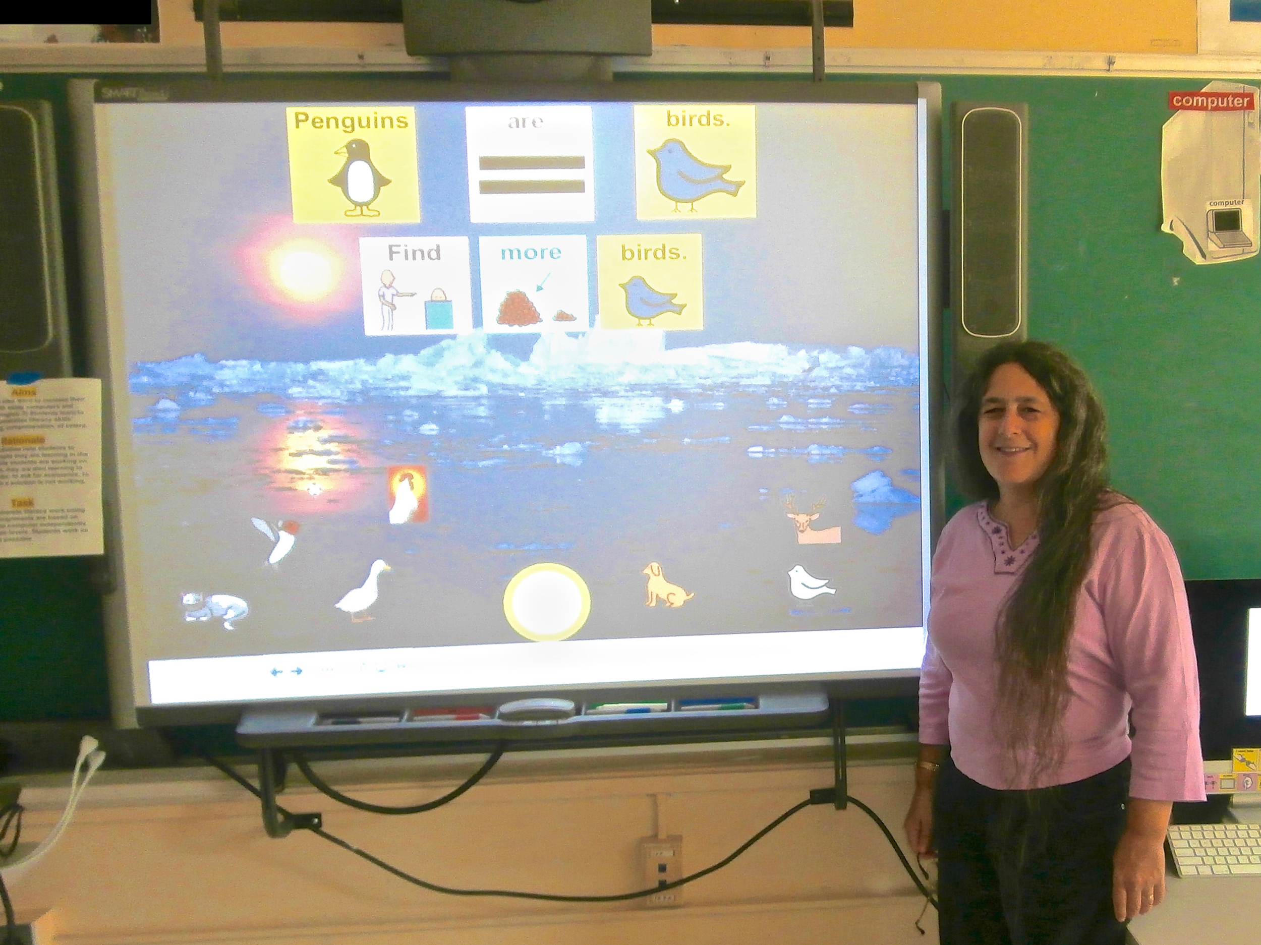 Jeanne Stork standing next to an interactive whiteboard activity that she created