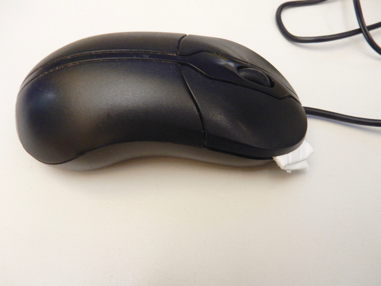 two-button mouse with folder paper towel under one button to disable it